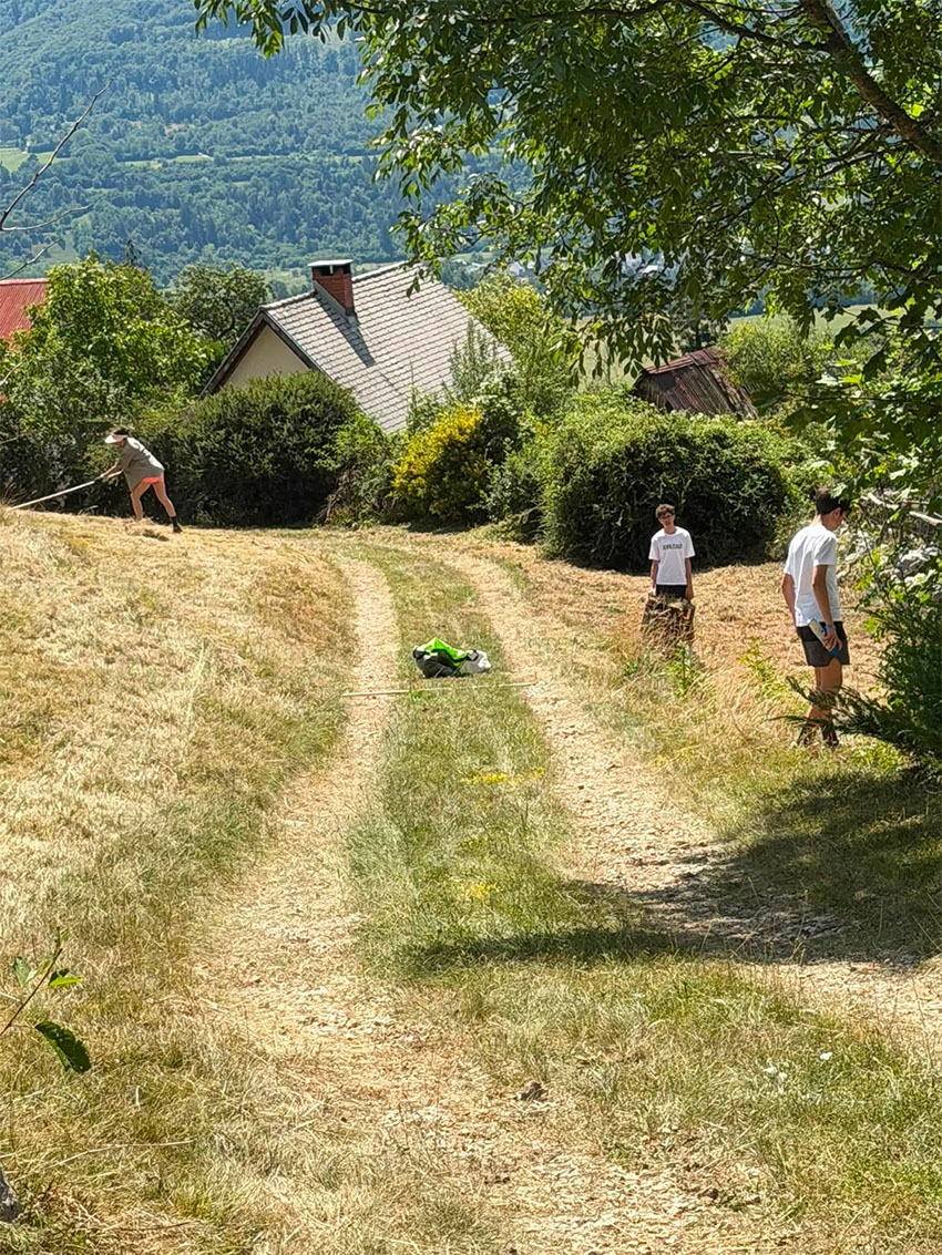 Sinova in soproga Janeza Janše med košnjo trave