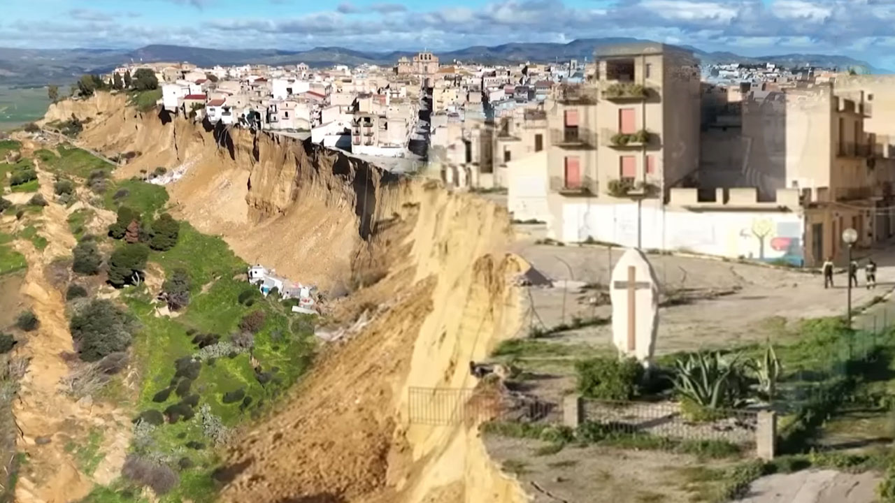 Zemeljski plaz v Niscemiju na Siciliji, zračni posnetek razsežnosti katastrofe in kamniti križ, ki stoji nad robom prepada