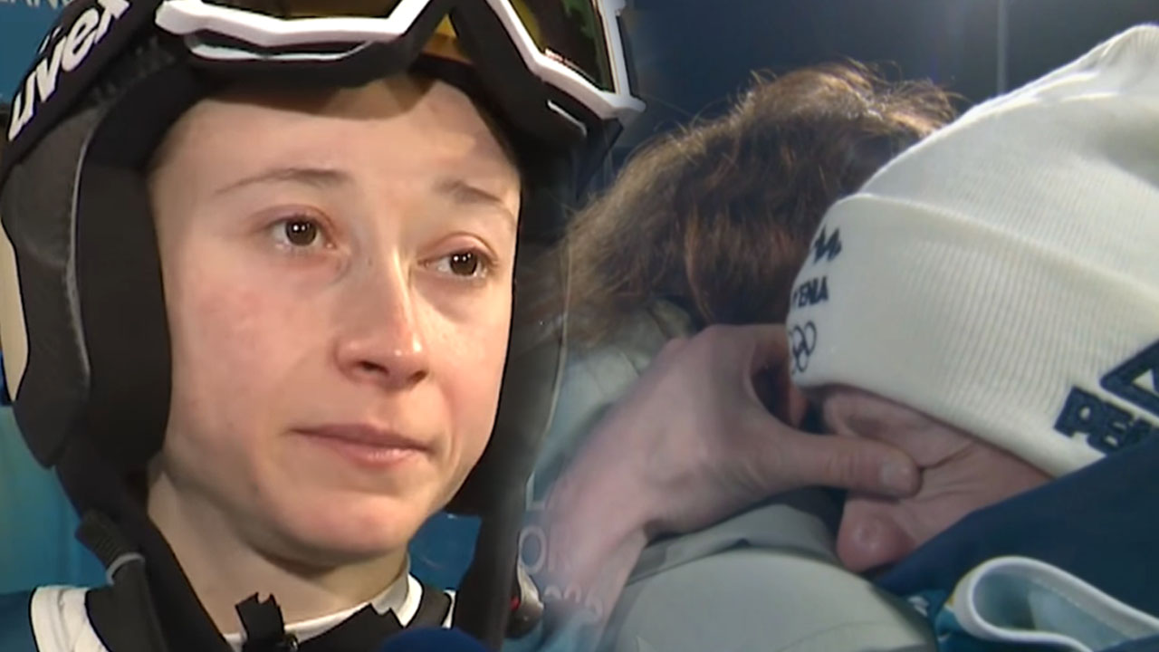 Nika Prevc v solzah po olimpijski tekmi v Predazzu v objemu staršev Julijane in Dareta