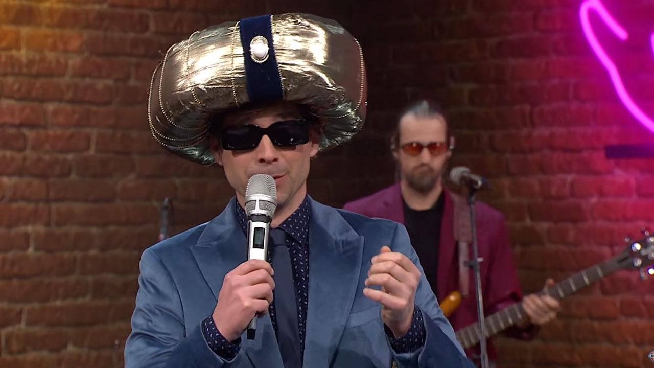 Tilen Artač v oddaji Kaj dogaja kot iranski voditelj – parodija Moj črni dron nasmejala gledalce