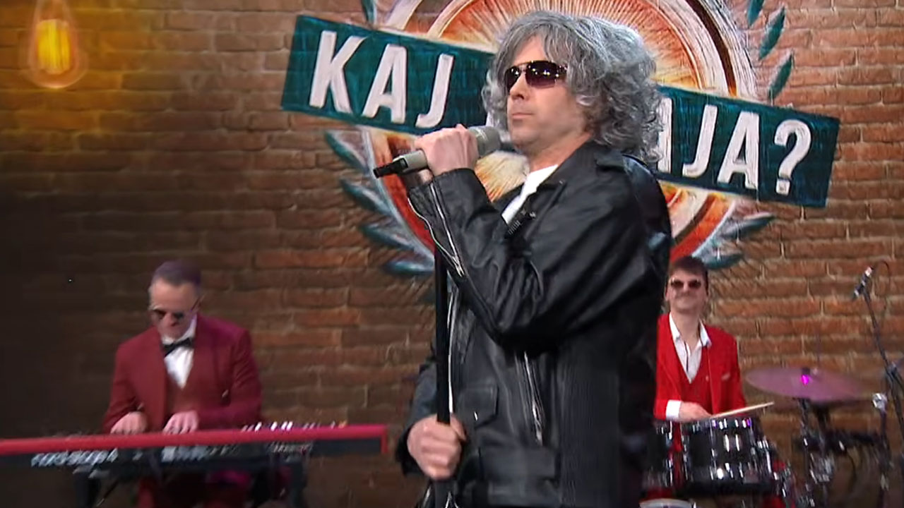 Tilen Artač v oddaji Kaj dogaja kot Robert Golob med parodijo pesmi o sestavljanju koalicije