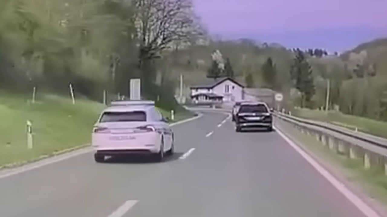 Policijsko vozilo med nevarnim prehitevanjem v ovinku pri Krnjaku