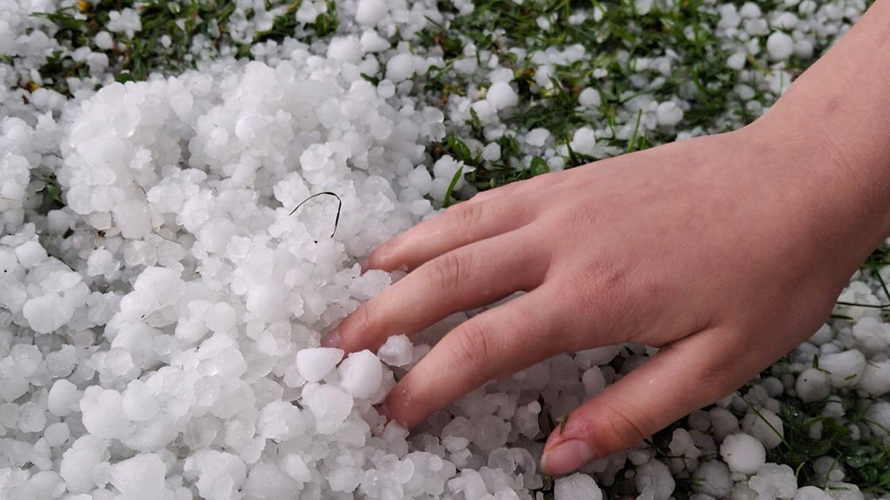 Drobna toča in sodra pobelita tla v slovenskem kraju med nevihto