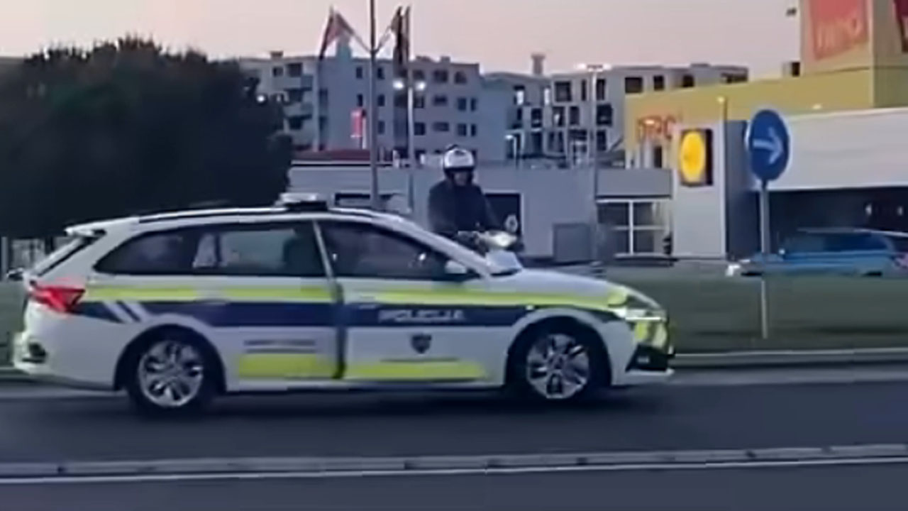 Voznik skuterja v Kopru vozi čez sredinsko zelenico krožišča pri nakupovalnem centru Planet Koper