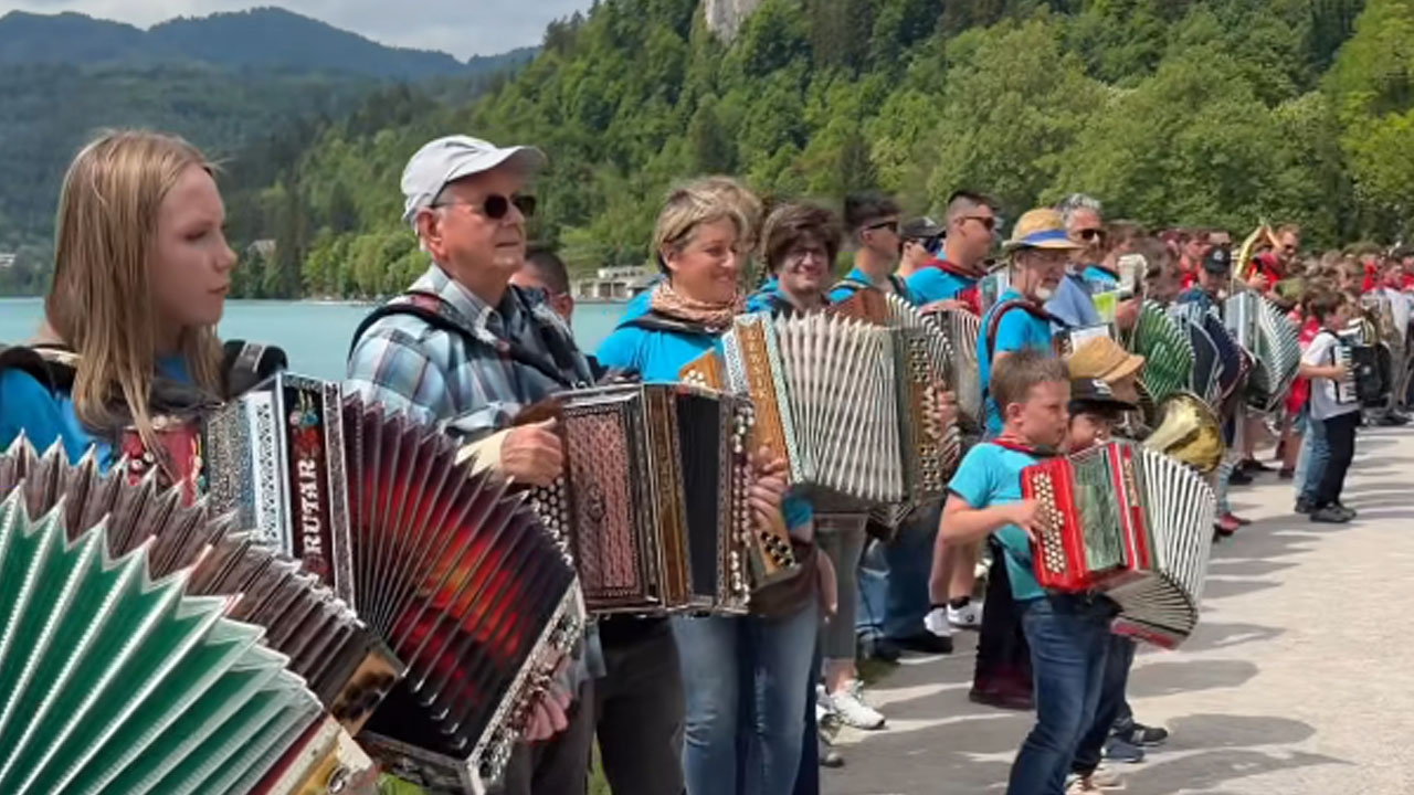 Množica harmonikarjev ob Blejskem jezeru igralo slovenske pesmi