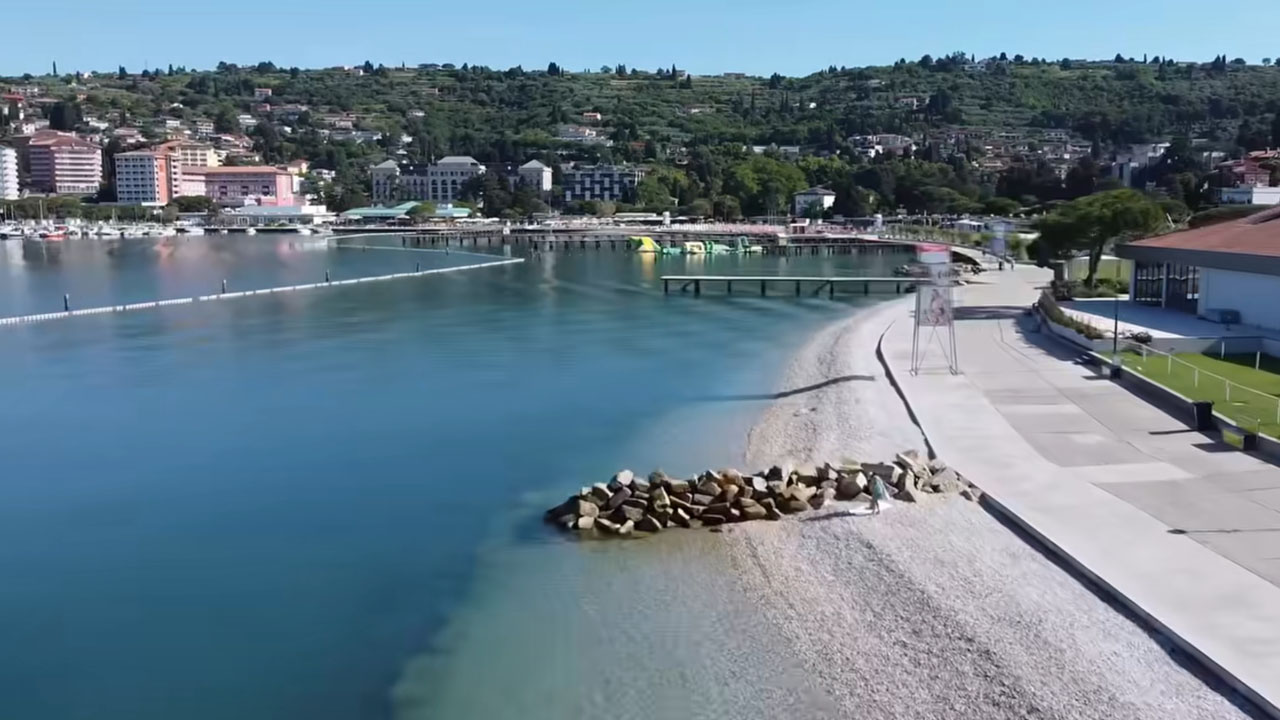 Plaža v Portorožu dobila novo podobo, nasuli so beli soški prod