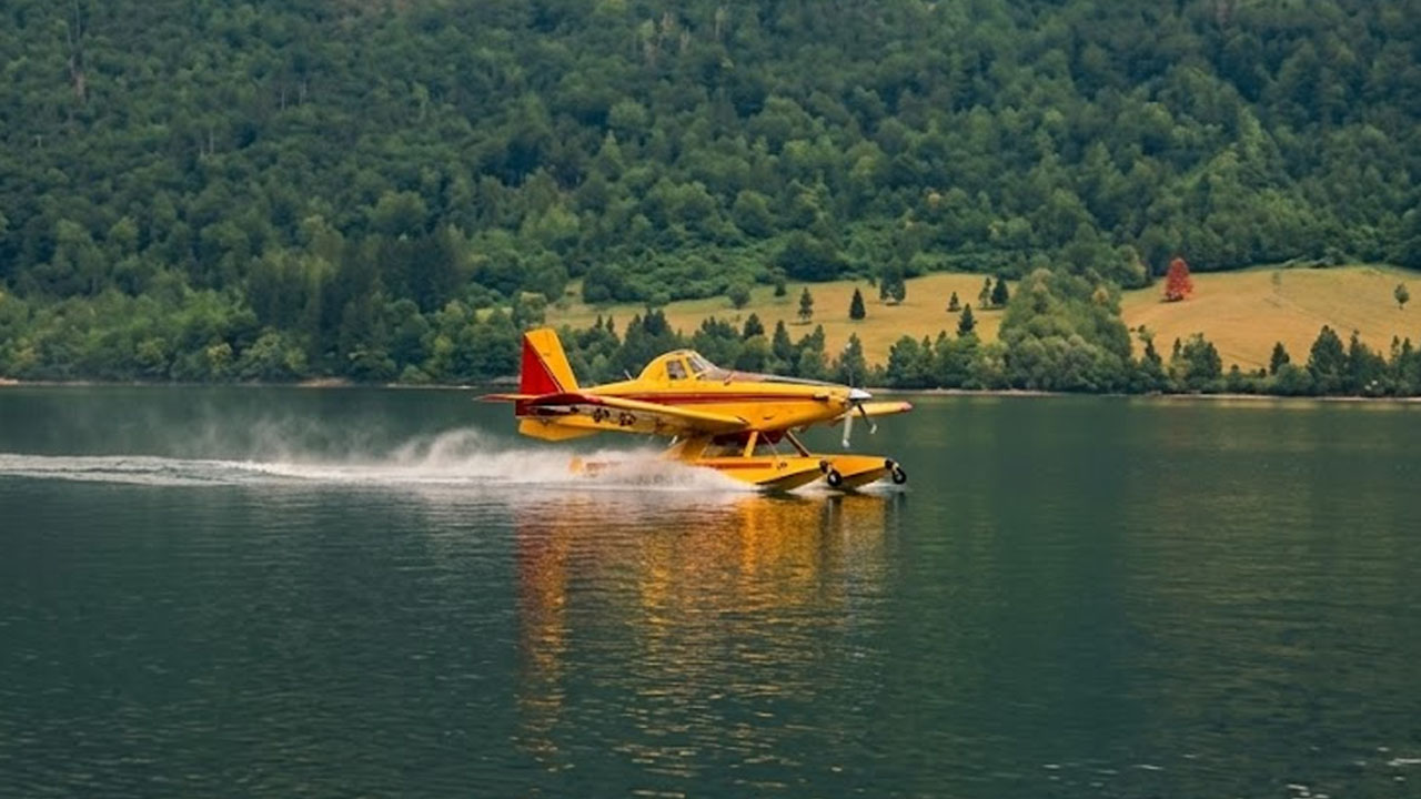 Letalo Air Tractor med zajemanjem vode iz Bohinjskega jezera za gašenje požara na planini Bela glava