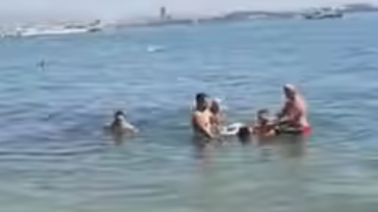 Trije mladeniči rešujejo žensko, ki je začela toniti na plaži Torac v Kaštel Gomilici