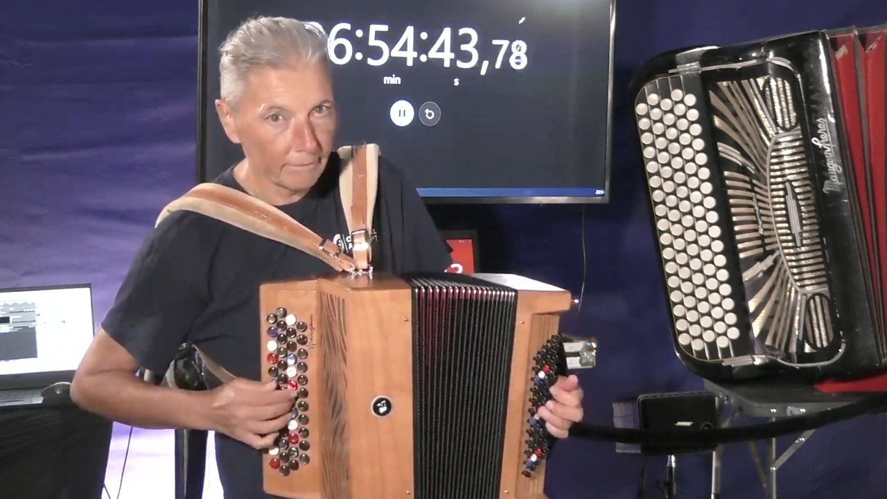 57-letna Christelle de Franceschi iz Francije ob zaključku rekordnega podviga pri igranju harmonike